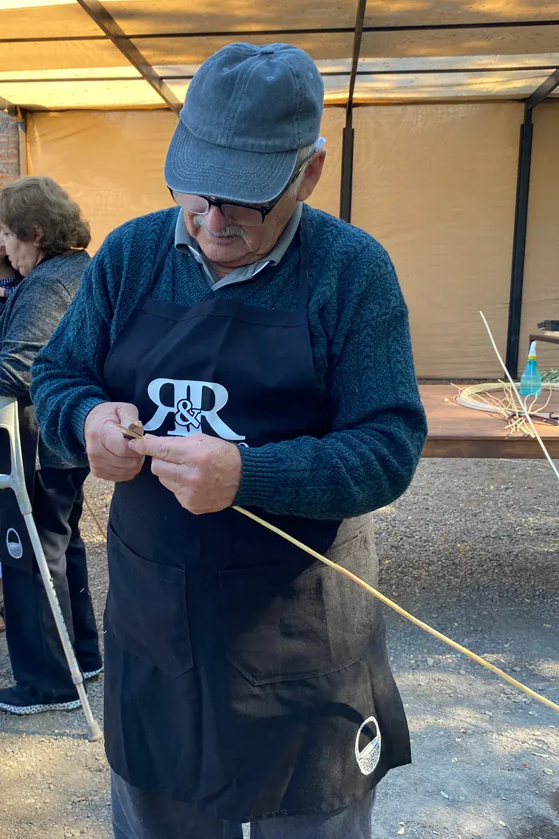The master craftsman splits a strip of wicker by hand