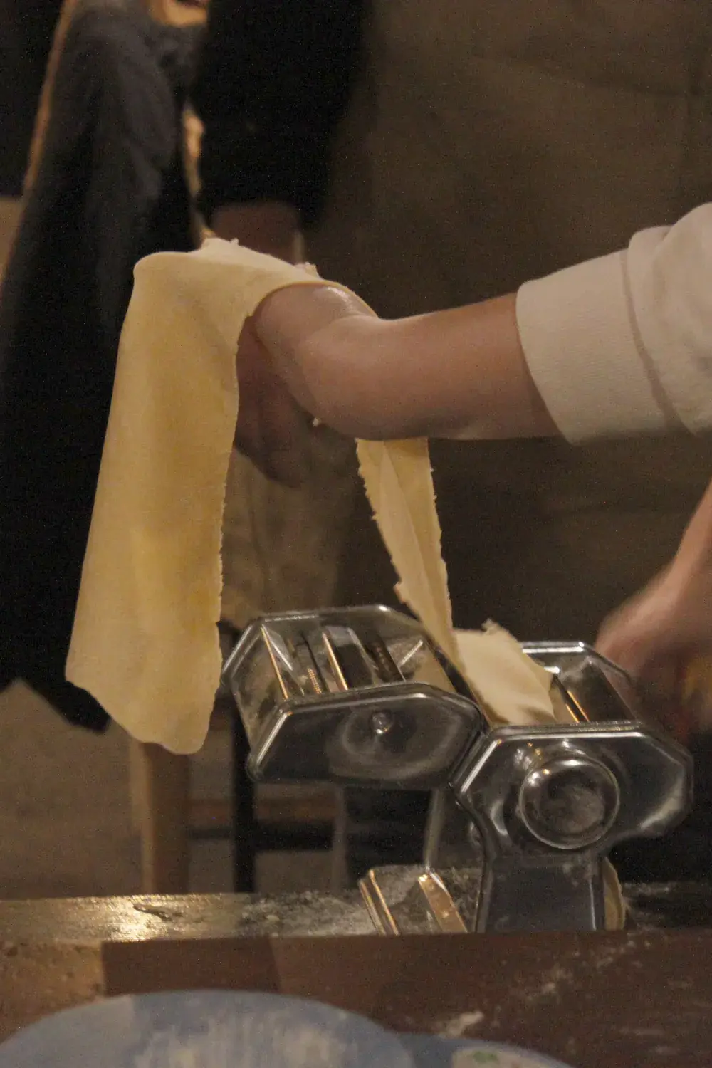 A sheet of fresh dough goes through the pasta machine
