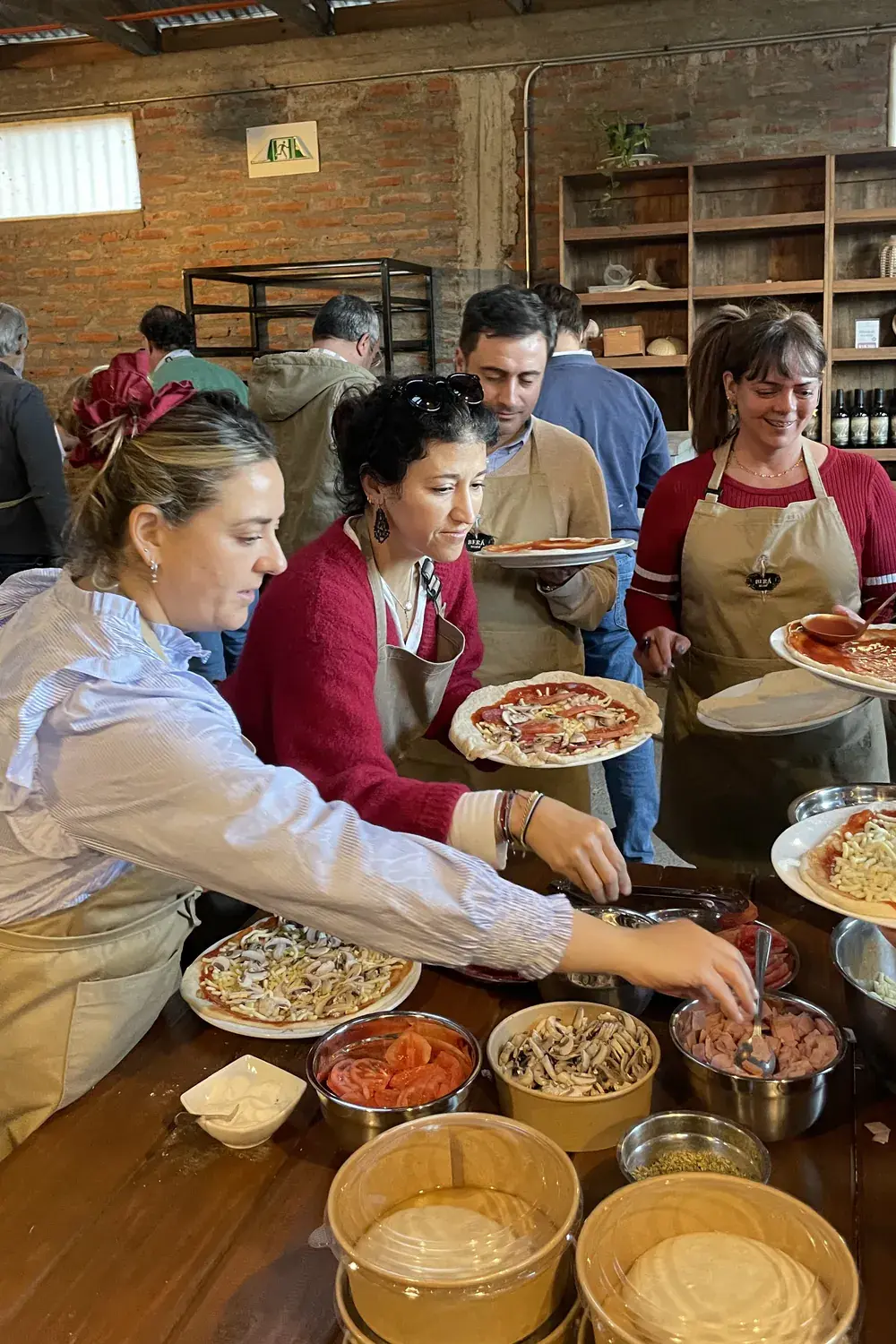 Participants top their pizzas at the ingredient counter