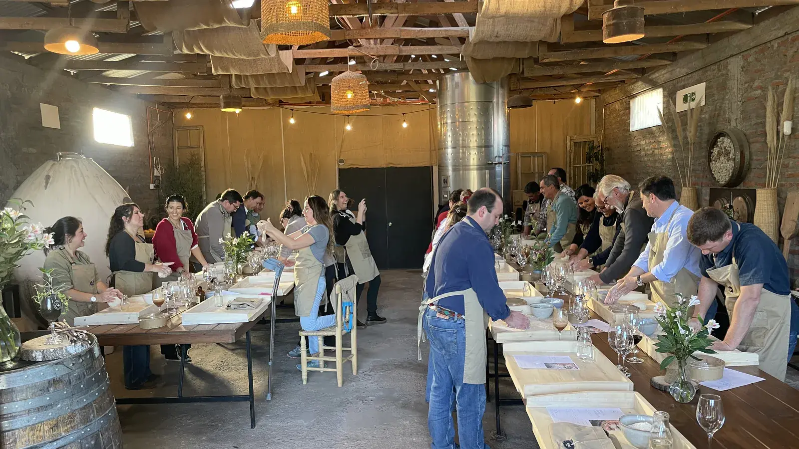 View of the winery hall with two rows of participants kneading at long tables