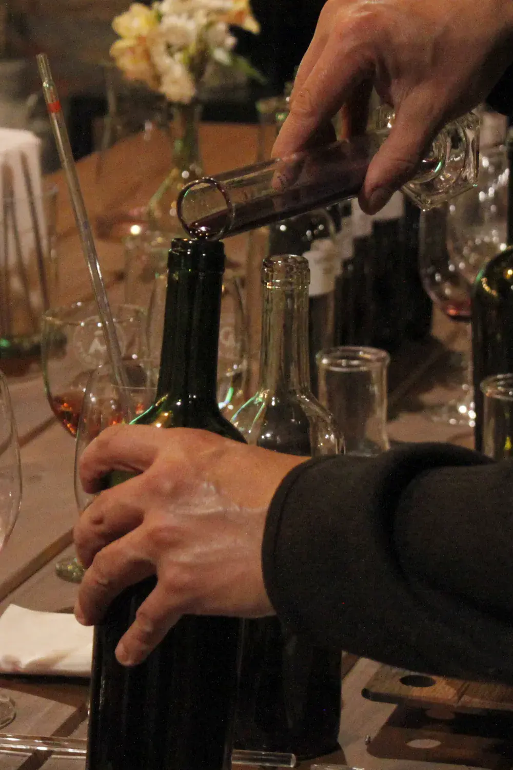 Hands pour the blend from a cylinder into the bottle