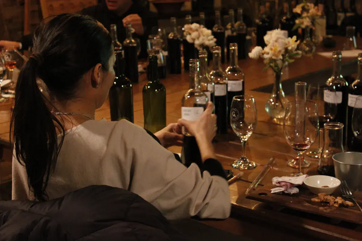Adjusting a bottle's label among rows of bottles and flowers