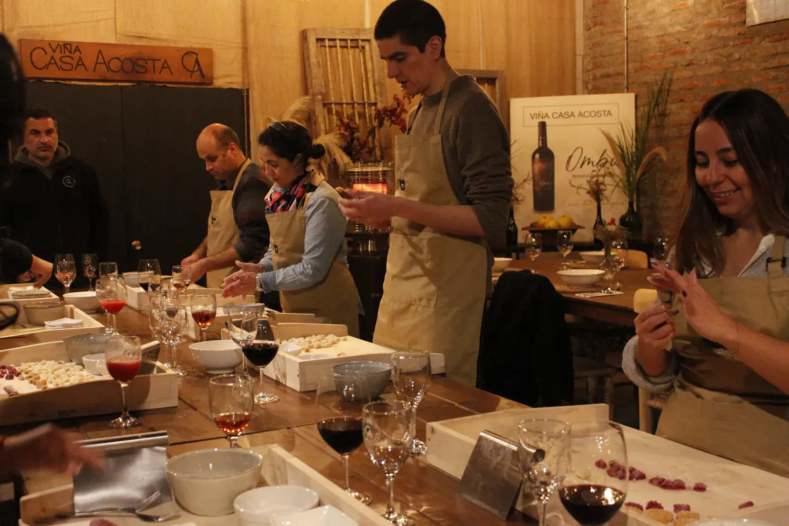A participant smiles while shaping gnocchi by hand at the workshop table