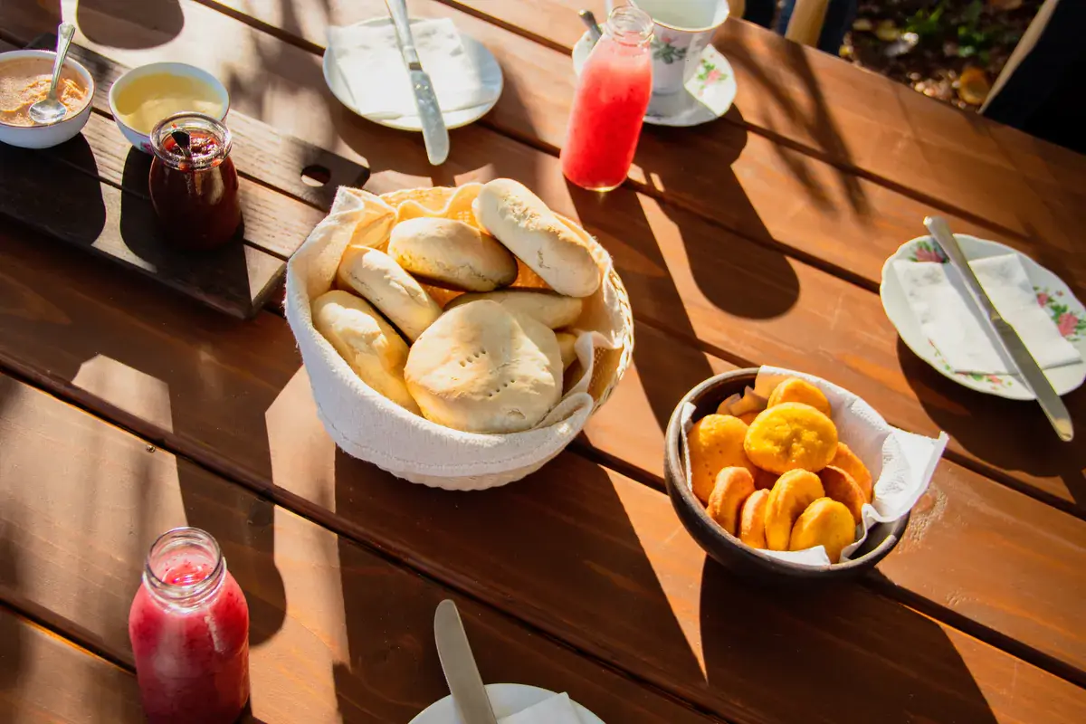 Homemade bread, fruit, jam and juice on the wooden breakfast table
